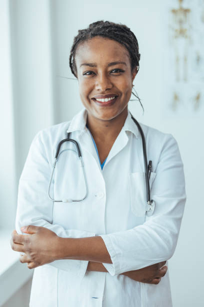 Portrait of a happy young doctor standing with her arms crossed