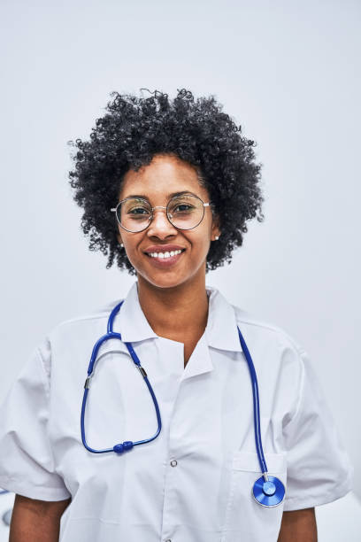 Portrait of a confident healthcare worker in hospital. African woman doctor is in lab coat and stethoscope against white background.